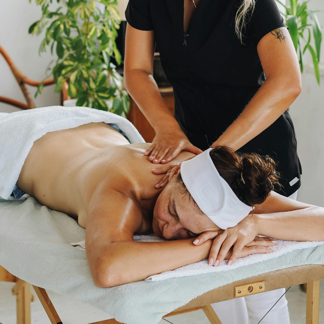 woman with a white headband receiving a back massage