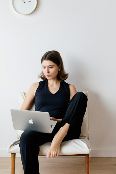 a woman wearing black clothes working on a laptop