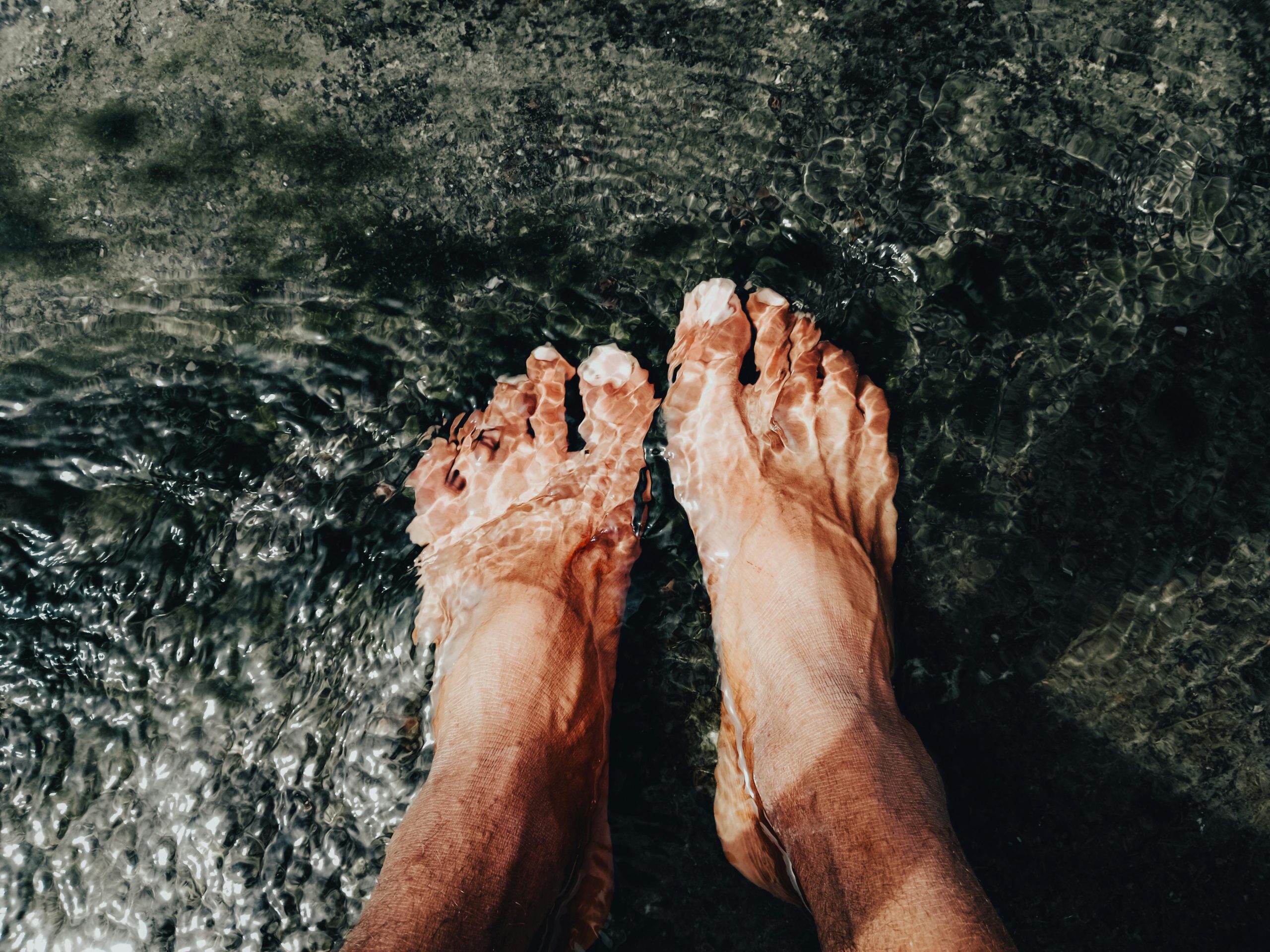 feet resting in a shallow pool of water